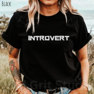 Puede incluir: Camiseta negra con la palabra "Introvertido" impresa en blanco en la parte delantera.