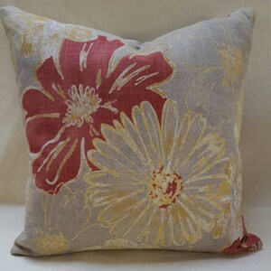 May include: Square decorative pillow with a floral pattern. The pillow features large red and yellow flowers on a gray background. The flowers have detailed petals and centers, adding a touch of elegance to the design.