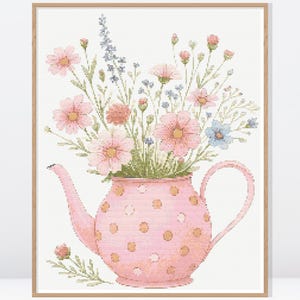 Può includere: Stampa artistica incorniciata di una teiera rosa a pois, piena di un bouquet di fiori. I fiori sono rosa, blu e pesca, con steli e foglie verdi. L'opera d'arte è ambientata su uno sfondo bianco.