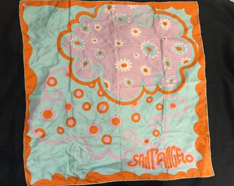 May include: A turquoise blue silk scarf with an orange border. The scarf features a pink and white floral design with a swirl pattern and the text "Sant'Angelo" in orange.