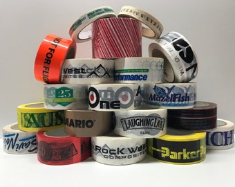 May include: A stack of various rolls of tape with different company logos and designs. The top roll has the text "NOT FOR FLIGHT" printed on it. Other rolls have logos such as "Westcove Sites", "One", "MazelFish", "Laughing Lab", "Rock West Composites", and "Parker".