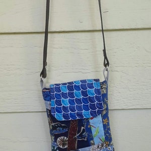 Bolso bandolera tipo sobre de tela con patchwork bohemio Willy Nilly en tonos azules y correa de cuero