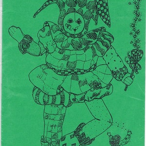 May include: A black and white line drawing of a jester doll with a green background. The doll is wearing a jester hat and a patterned outfit. The text "A Motley Fool!" is at the top of the image. The text "Elise Peeples Dolls" is at the bottom of the image.