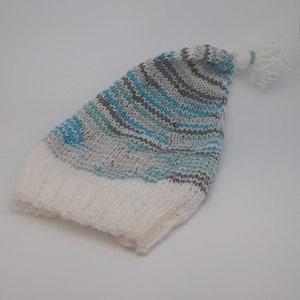 May include: A white and blue striped knitted baby hat with a white pom-pom on top.