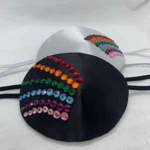 Peut inclure: Deux patchs oculaires avec des motifs de strass arc-en-ciel. Un patch oculaire est en satin noir et l'autre en satin blanc.