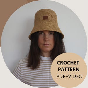 Könnte beinhalten: Ein Häkelmuster für einen beigen Bucket-Hut mit einem braunen Leder-Patch. Das Muster beinhaltet eine PDF-Anleitung und ein Video. CROCHET PATTERN PDF+VIDEO