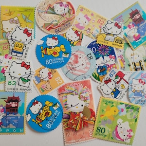 Op de afbeelding: Een verzameling kleurrijke Japanse postzegels met het personage Hello Kitty. De postzegels tonen verschillende ontwerpen, waaronder Hello Kitty in verschillende outfits en omgevingen, met Japanse tekst en cijfers.
