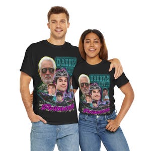 Puede incluir: Dos personas con camisetas negras con un estampado gráfico de un grupo de personas con coronas y el texto "Daddy's Little Princess".