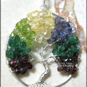 May include: A silver wire wrapped tree of life pendant with a variety of gemstones including green, yellow, purple, and red.