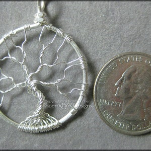 May include: Silver wire tree of life pendant necklace, approximately the size of a UK 20 pence coin.