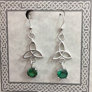 Puede incluir: Pendientes de nudo celta de plata con gotas de piedras preciosas verdes.
