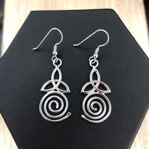 May include: Silver dangle earrings with a Celtic knot design and a spiral detail.