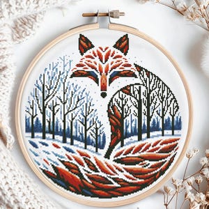 Peut inclure: Un cerceau de broderie au point de croix avec un motif de renard roux dans une forêt d'hiver. La queue du renard est enroulée autour des arbres, créant un motif circulaire. Les arbres sont bleus et blancs, et l'arrière-plan est blanc.