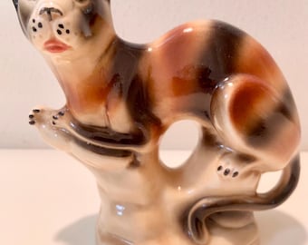 Figura de porcelana vintage de un jaguar, apoyada sobre un pedestal o base, fabricada en Brasil.
