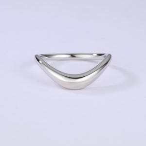 May include: A simple silver band ring with a curved, v-shaped design.