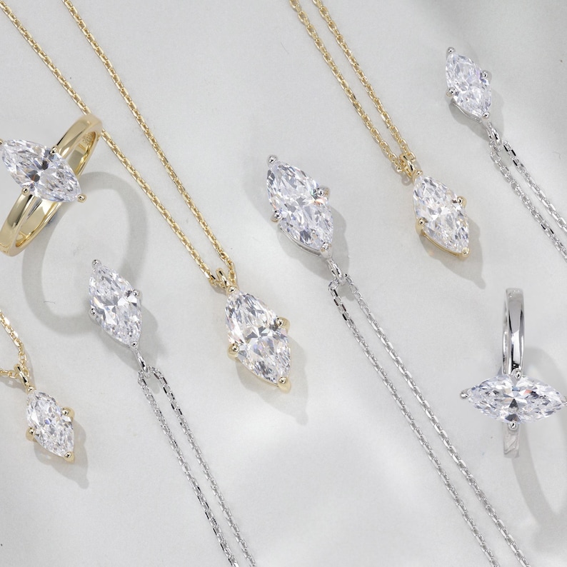May include: A set of six marquise-cut diamond pendants and rings in silver and gold settings. The diamonds are clear and sparkly.