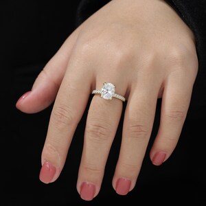 Op de afbeelding: Een gouden verlovingsring met een grote ovale diamant als middelste steen en een band met kleinere diamanten.