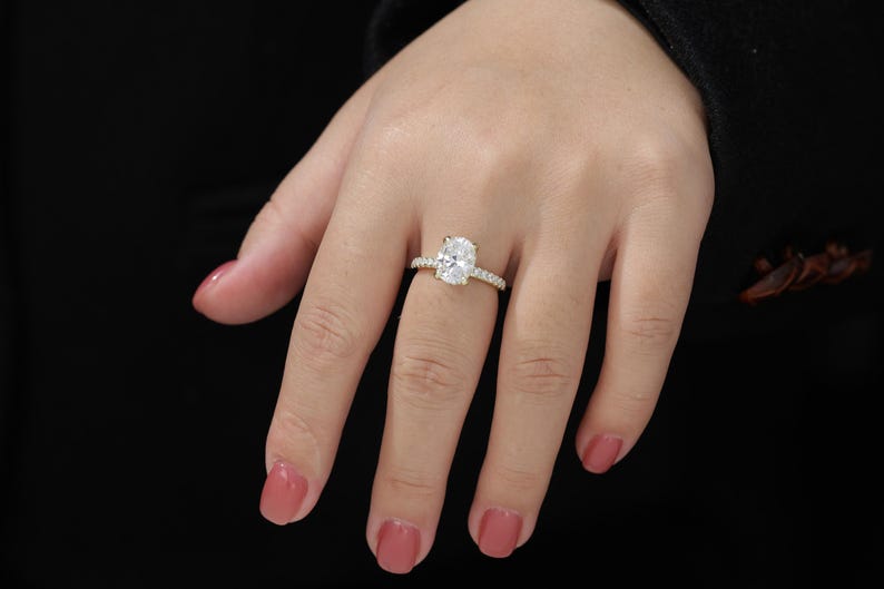 Op de afbeelding: Een gouden verlovingsring met een grote ovale diamant als middelste steen en een band met kleinere diamanten.