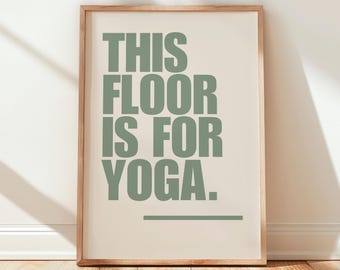 May include: A framed print with the text "THIS FLOOR IS FOR YOGA." in a sage green color on a cream background.