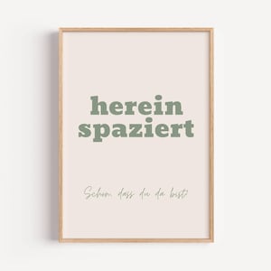 Könnte beinhalten: Ein gerahmter Druck mit hellrosa Hintergrund und grünem Textüberlagerung, der "herein spaziert" und "Schon dass du da bist" lautet.
