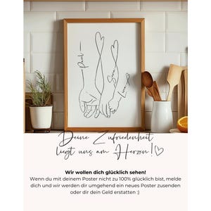 May include: A framed art print featuring a black line drawing of intertwined hands with heart-shaped extensions. Names are written above the hands. The print is in a wooden frame, with text below in German.