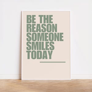 Könnte beinhalten: Ein beiger Poster mit weißem Rand, auf dem der Text "BE THE REASON SOMEONE SMILES TODAY" in Grün steht.