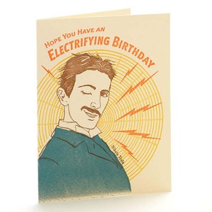 May include: A folded birthday card with a vintage illustration of Nikola Tesla winking. The card has the text "HOPE YOU HAVE AN ELECTRIFYING BIRTHDAY" in orange and the name "Nikola Tesla" at the bottom.