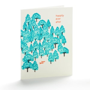 May include: A folded greeting card with a forest illustration. The trees are teal with black trunks, and two orange foxes are at the bottom. The words "happily ever after" are in orange on the right side of the card.