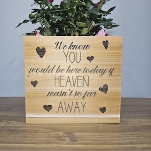 May include: Wooden planter box with a message that reads "We know you would be here today if heaven wasn't so far away". The planter is decorated with hearts and has a small potted rose plant inside.