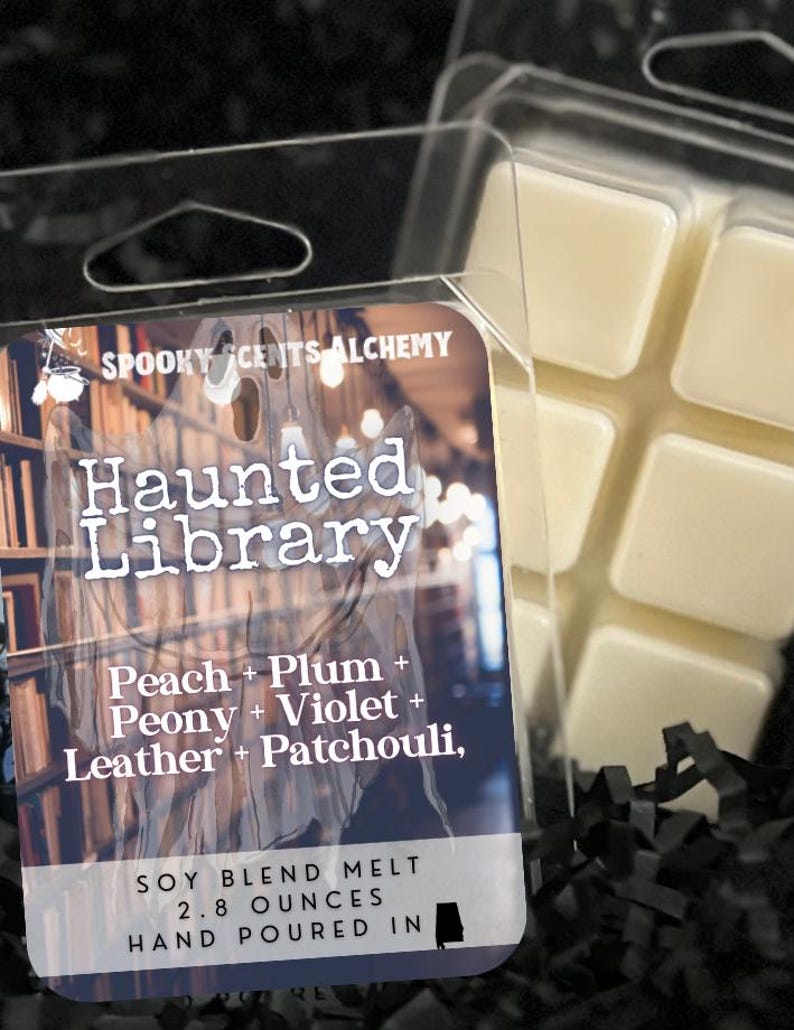 May include: A clear plastic clamshell package containing a soy blend wax melt. The label reads "Haunted Library" with scent notes. The wax melt is 2.8 ounces. The wax is a light beige color.