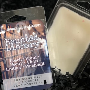 May include: A soy blend wax melt in a clear plastic package. The label reads "Haunted Library" with scent notes of peach, plum, peony, violet, leather, and patchouli. The package contains 2.8 ounces of wax.