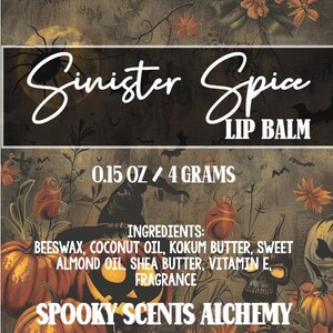 May include: A Halloween-themed lip balm product with the text "Sinister Spice LIP BALM". The label includes the weight, 0.15 oz / 4 grams, and ingredients. The design features pumpkins, bats, and a witch's hat.