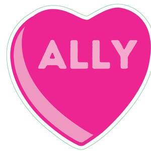 May include: A pink heart-shaped candy with the word "ALLY" in white block letters. The candy has a light pink highlight and a green outline, set against a white background. This design is reminiscent of Valentine's Day treats.