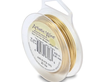 May include: A spool of 15 yards of 20 gauge gold-colored non-tarnish brass wire. The spool is labeled "Artistic Wire" and has the text "Non-Tarnish Brass, Laiton Non Ternissant, Latón Claro" printed on it. The wire is 0.032 inches in diameter.
