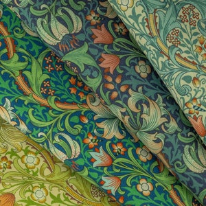 May include: Close-up of three fabric swatches with floral patterns. The patterns feature green, blue, orange, and yellow flowers on a dark blue background.