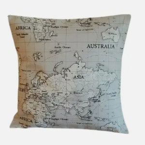 Può includere: Un cuscino beige con una stampa di mappa del mondo in bianco e nero. La mappa mostra i continenti di Africa, Asia, Europa, Australia e Nord America. Il cuscino è realizzato in un tessuto morbido e confortevole.