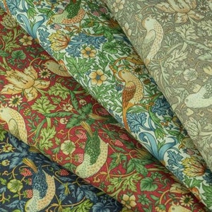 Puede incluir: Primer plano de tres muestras de tela diferentes con un patrón floral y de pájaros. Las telas son en tonos de verde, azul, rojo y marrón.