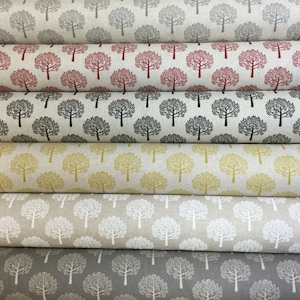 Puede incluir: Varios rollos de tela con un diseño repetido de árboles. Las telas muestran árboles en tonos de gris, rojo, negro, amarillo, blanco y un gris más claro, sobre fondos neutros. El patrón de árboles es consistente en todos los rollos, ideal para proyectos.