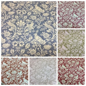 Può includere: Un collage di sei campioni di tessuto con un motivo ripetitivo di uccelli stilizzati, conigli e disegni floreali. I campioni sono di vari colori, tra cui blu, verde, rosso e beige.