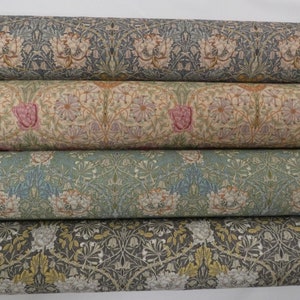 May include: Four rolls of fabric featuring a floral design in shades of blue, green, brown, and pink. The fabric has a repeating pattern of flowers and leaves.