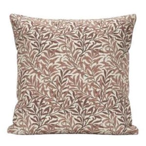 Op de afbeelding: Vierkant decoratief kussen met een herhalend patroon van bruine en beige gestileerde bladeren en takken. Het kussen heeft een zacht, getextureerd uiterlijk en is waarschijnlijk gemaakt van stof. Het ontwerp doet denken aan een botanische print.