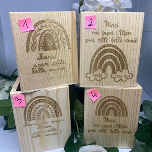 Peut inclure: Quatre boîtes en bois avec des motifs arc-en-ciel et des messages gravés. Les boîtes sont numérotées de 1 à 4. Les messages sur les boîtes incluent "Merci ma super Atsem pour cette belle année" et "Merci ma super Atsem pour cette belle année".