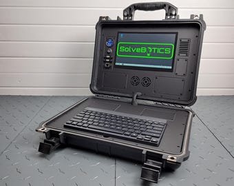 Może przedstawiać: Czarna, wytrzymała walizka na laptopa z wbudowaną klawiaturą i ekranem wyświetlającym tekst "SolveBotics".