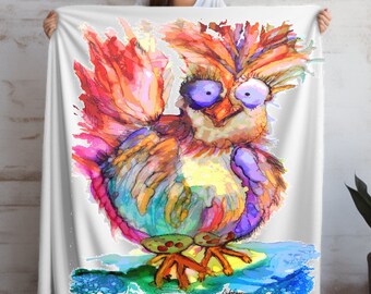 Può includere: Una coperta bianca con un'illustrazione ad acquerello colorata di un pollo con il testo "Crazy Chicken Lady" stampato in basso.