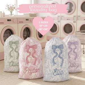 May include: Four personalized laundry bags with floral patterns and bow accents. Each bag is a different color: green, pink, blue, and purple. The bags are labeled with names and the text "personalized laundry bag". Two sizes are available: 18"x29" and 28"x36".