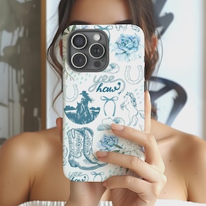 May include: A white iPhone case with a blue cowboy-themed pattern. The design includes horseshoes, cowboy boots, roses, a cowboy on a horse, and the words "Yee Haw". The case has a glossy finish and a camera cutout.