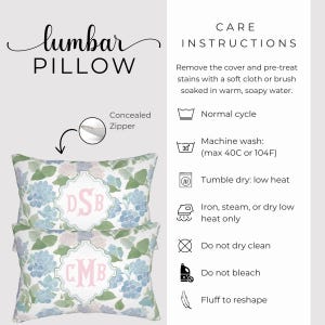 May include: Two rectangular lumbar pillows featuring a blue and green hydrangea floral pattern with a central white scalloped frame containing pink monogram letters. The design includes a concealed zipper and detailed care instructions for maintenance.