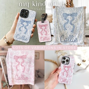 May include: A collection of personalized items with a floral pattern and a bow design. Items include a phone case, luggage tag, and blanket, each with the name "Callie". The phone case and blanket are light blue, while the luggage tag and other blanket are pink.