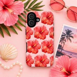 Pink hibiscus floral phone case displayed in a tropical flat lay with oversized hibiscus flowers, palm leaves, pearl bracelet, seashell, and pink sunglasses. Feminine summer aesthetic iPhone case with watercolor hibiscus pattern on a soft blush pink background, perfect for tropical vacations, beach lovers, Hawaii trips, and coquette-inspired phone accessories.