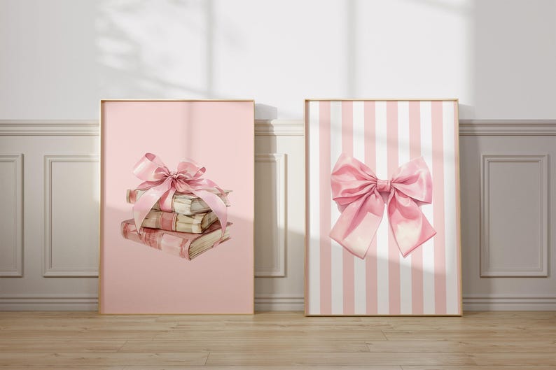My cute coquette set of three pink bow prints. The bows have a watercolour look to the. Two prints have white and pink stripes in the background with a large bow in front. The middle print has a book stack on a pink background with a bow. Nursery Art